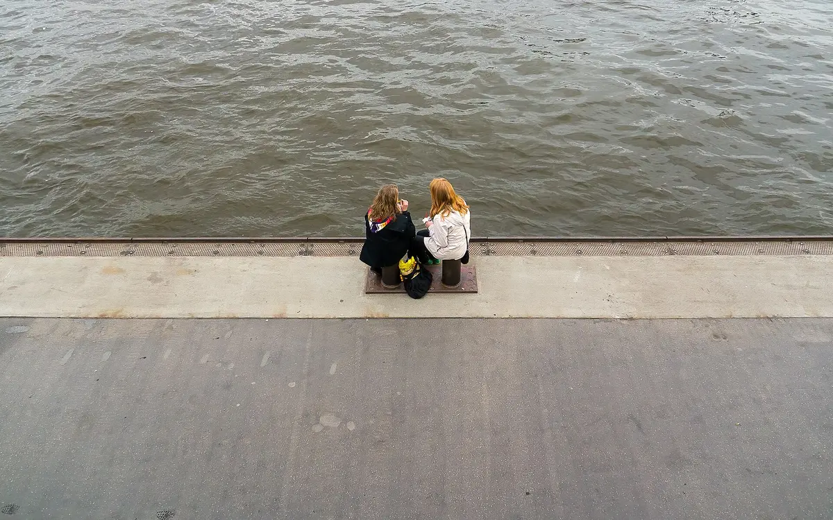 People sitting on the Elbe waterfront at the St. Pauli Landungsbrücken