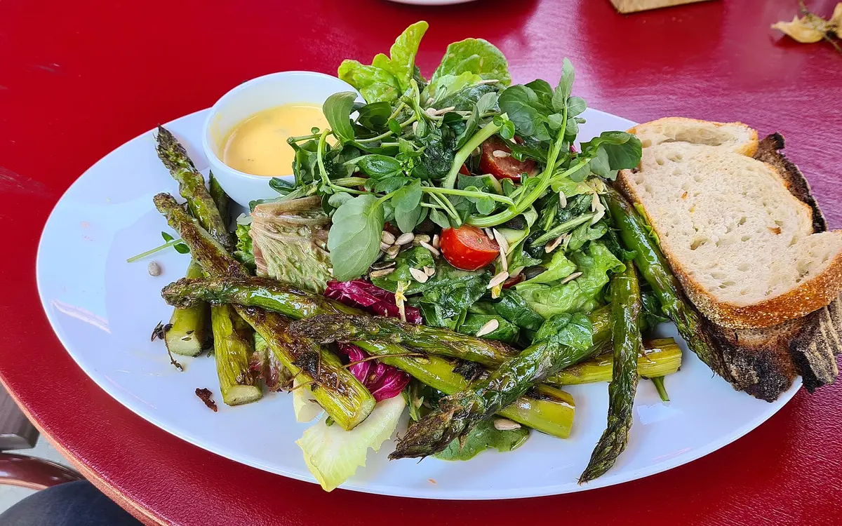 A plate of green asparagus salad with bread
