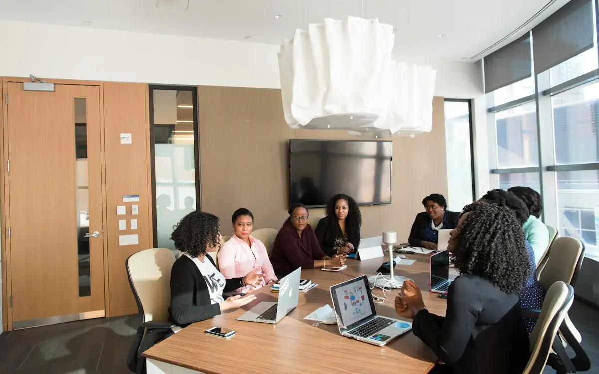 Team meeting around a conference table with laptops